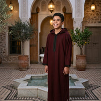 Kids winter Djellaba from Al-Andalus, cozy traditional Moroccan garment in warm fabric, with intricate patterns and a hood.