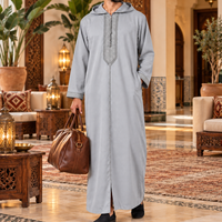 Gray Soft Jellaba worn in a Moroccan boutique hotel with a travel bag